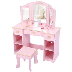 a pink desk with a mirror and stool on it's side, next to a teddy bear