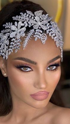 a woman wearing a tiara with flowers on it's head and an eyeliner