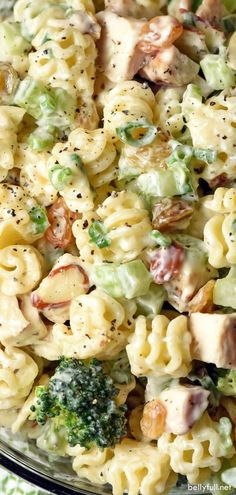 a pasta salad with broccoli and chicken in a glass bowl on a table