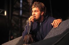 a man with headphones is sitting on a stage and looking at something in his hand