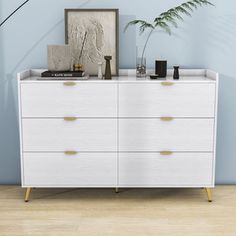 a white dresser with some plants on top