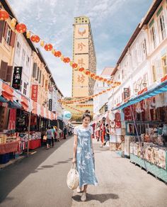 a woman in a blue dress is walking down the street