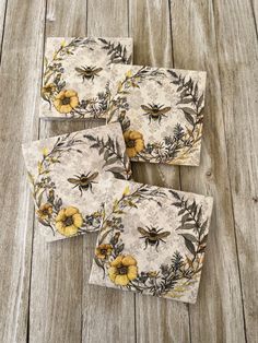 four bees and yellow flowers on white paper napkins with wood flooring in the background