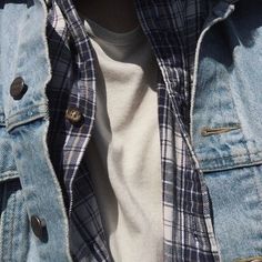 a close up of a person wearing a jean jacket and white t - shirt with buttons