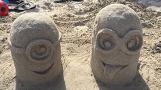 two sand sculptures made to look like faces in the sand