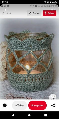 a crocheted glass candle holder is shown on the instagram page, which has an image of a lit candle in it