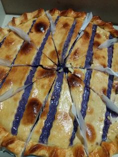 a close up of a pie in a box with purple and white strips on it