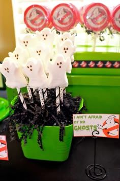 there are some candy sticks in a green bucket on the table with other decorations around it