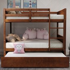 a bunk bed with three pillows on the bottom and two stuffed animals on the bottom