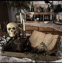 there is a skull on the table next to an open book and some other items