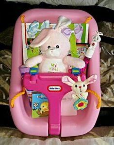 a pink baby walker with stuffed animals in it