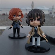 two anime figurines sitting on top of a table