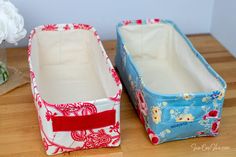 two storage containers sitting on top of a wooden table