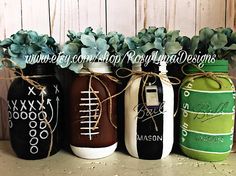 four painted mason jars with plants in them