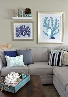 a living room filled with furniture and pictures hanging on the wall above it's coffee table