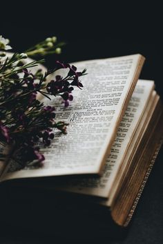 an open book sitting on top of a table next to purple flowers and the words fearless mothers have a blessed mother's day