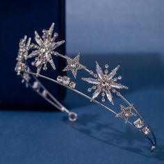 a tiara with crystal snowflakes on the top and bottom, sitting next to a black box