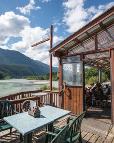 an outdoor dining area overlooking the water and mountains