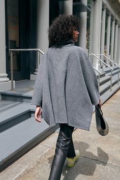 A stylish wool winter cloak, our Avery Cape is the ideal choice for heading out into the cold. Fashioned from Italian virgin wool and offered in fresh neutrals that pair well with any combination of clothing, this women’s wool cape is designed with a loose silhouette. Simple. Elegant. Cozy. Layer her over anything for an instant ready-to-go look. Avery's high collar has a side zipper for style and easy wear. This wool winter cape is lined for added warmth and comfort. | Astrid, in medium grey an Cape Clothing, Winter Cloak, Cape Outfit, Winter Cape, Cape Jacket, Wool Cape, Wool Winter, Cape Coat, Simple Elegant