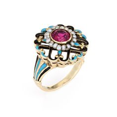 This is part of Chairish’s Fine Jewelry assortment.  Elegant and finely detailed Edwardian era enamel ring (circa 1900s to 1910s), crafted in 14 karat yellow gold.    Created ruby measures 5mm (in very good condition and free of cracks or crisps). Small natural 1mm seed pearls surround the ruby.   A created ruby is set into a beautifully detailed scrolled mount. Blue and black enamel adds a pop of colour, offering contrast to the ruby that is striking and unique. The ring is small in size (2 1/2 Yellow Gold Enamel Jewelry With Rose Cut Diamonds, Fine Jewelry Enamel Ring Hallmarked, Ornate Yellow Gold Ruby Ring With Intricate Design, Yellow Gold Enamel Ring With Rose Cut Diamonds, Antique Enamel Ring Collectible, Antique Enamel Rings For Collectors, Antique Enamel Rings As Collectibles, Vintage Yellow Gold Enamel Rings, Vintage Enamel Ring With Rose Cut Diamonds As Gift