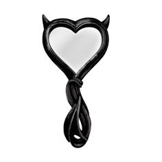 a heart shaped mirror hanging from the side of a hook on a white wall with a black cord attached to it