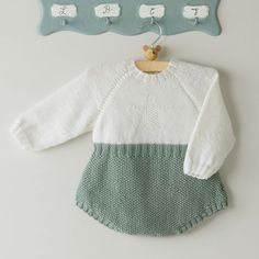 a baby sweater hanging on a coat rack next to a teddy bear wall hanger