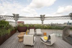 an outdoor deck with chairs and plants on it