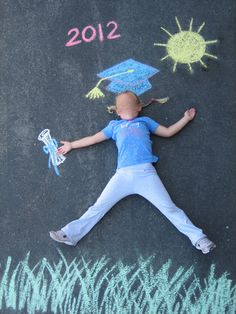 a child laying on the ground with chalk drawings