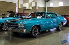 several classic cars are parked in a garage