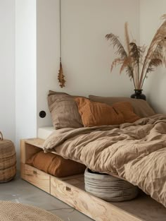 a bed that has some pillows on top of it and a basket next to it