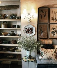 a room filled with lots of plates and vases on top of shelves next to a table