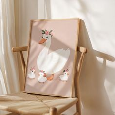 a white duck and her chicks are standing in front of a framed photo on a chair