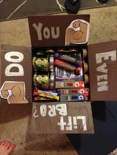 a cardboard box filled with different types of candy and candies on top of carpet