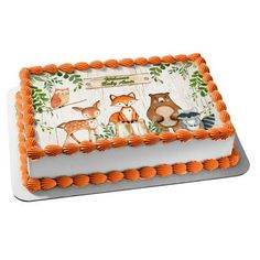 an orange and white cake with woodland animals on the frosting is sitting on a plate