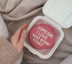 someone is holding a pink cookie in a plastic container with the words i love you today written on it