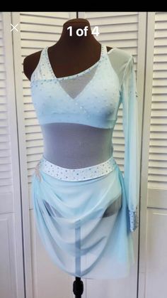 a mannequin wearing a dress made out of fabric and mesh with beading on it