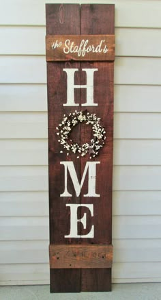 a wooden sign that says the word home is made out of wood and has a wreath on it