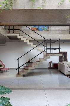 an open living room with stairs leading up to the second floor