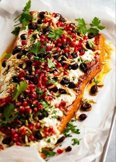 a fish covered in lots of toppings and garnished with cilantro