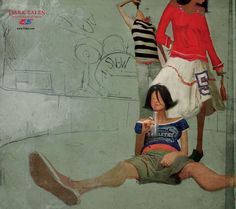 two women and a man are sitting on the ground in front of a wall with graffiti