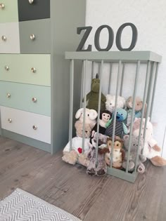 stuffed animals are placed in a baby's crib next to a dresser with the word zoo written on it