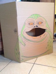 a cardboard box that has an image of a frog in it's mouth on the floor