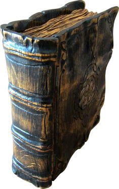 an old wooden book with carvings on the cover is shown in close up, it appears to have been carved from wood