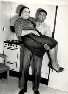 black and white photograph of man holding woman in kitchen