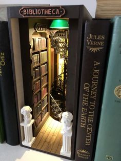 there are three books on top of each other in the same bookcase, and one is open