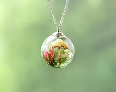 a glass ball with flowers in it hanging from a chain