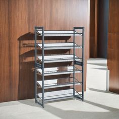 an empty shelf in front of a wooden wall with shelves on each side and two rows of shelving