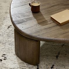 a wooden table with a book and cup on it