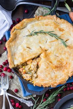 a pie with a slice missing from it on a blue plate next to cranberries