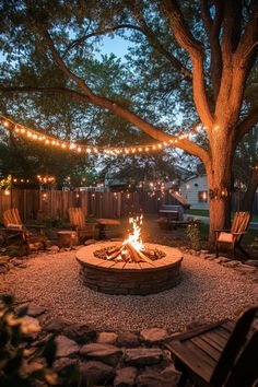 Backyard with a lit fire pit surrounded by Adirondack chairs and string lights hanging from trees. Farm Fire Pit Ideas, Fire Pit And Grill Area Patio Design, Fire Pit Lounge Area, Fire Pit And Pergola Backyard Ideas, Outside Sitting Area Ideas, Simple Backyard Fire Pit Ideas, Sunken Fire Pit With Seating, Brick Patio With Fire Pit, Fire Pit Aesthetic